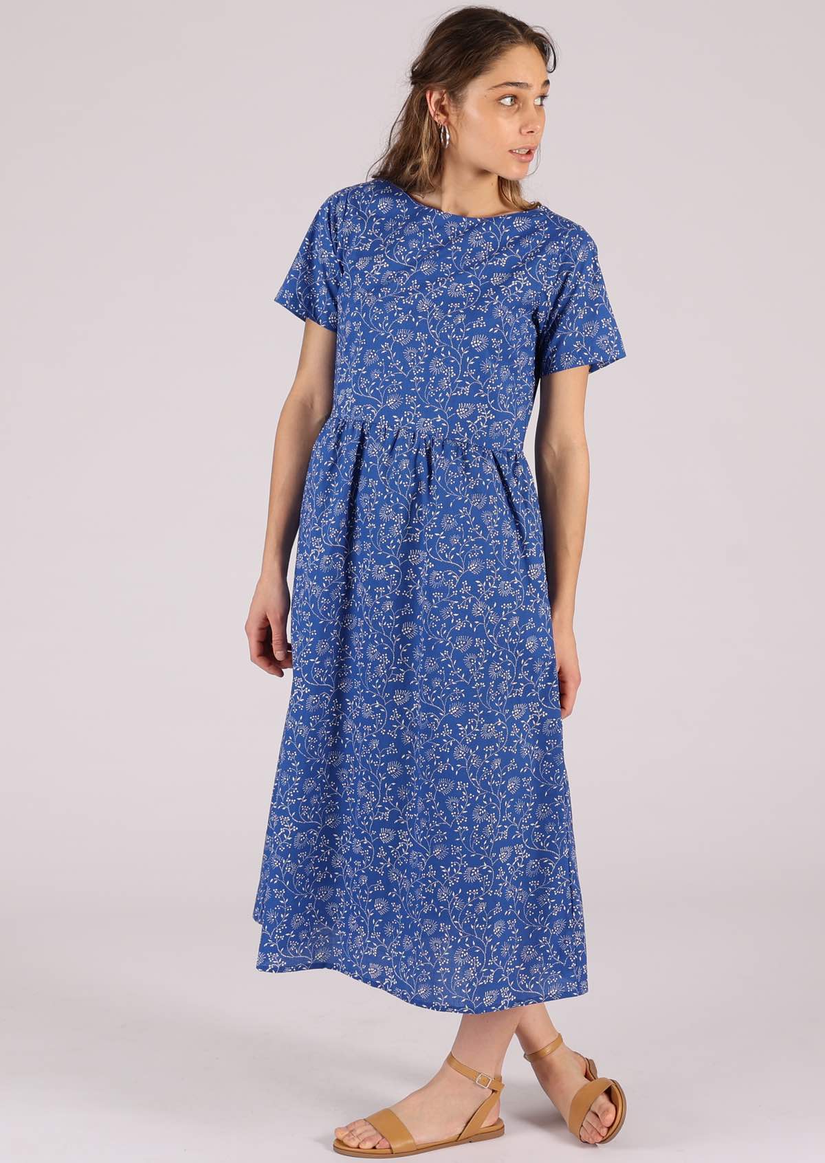Model wears blue based dress with short sleeves. 