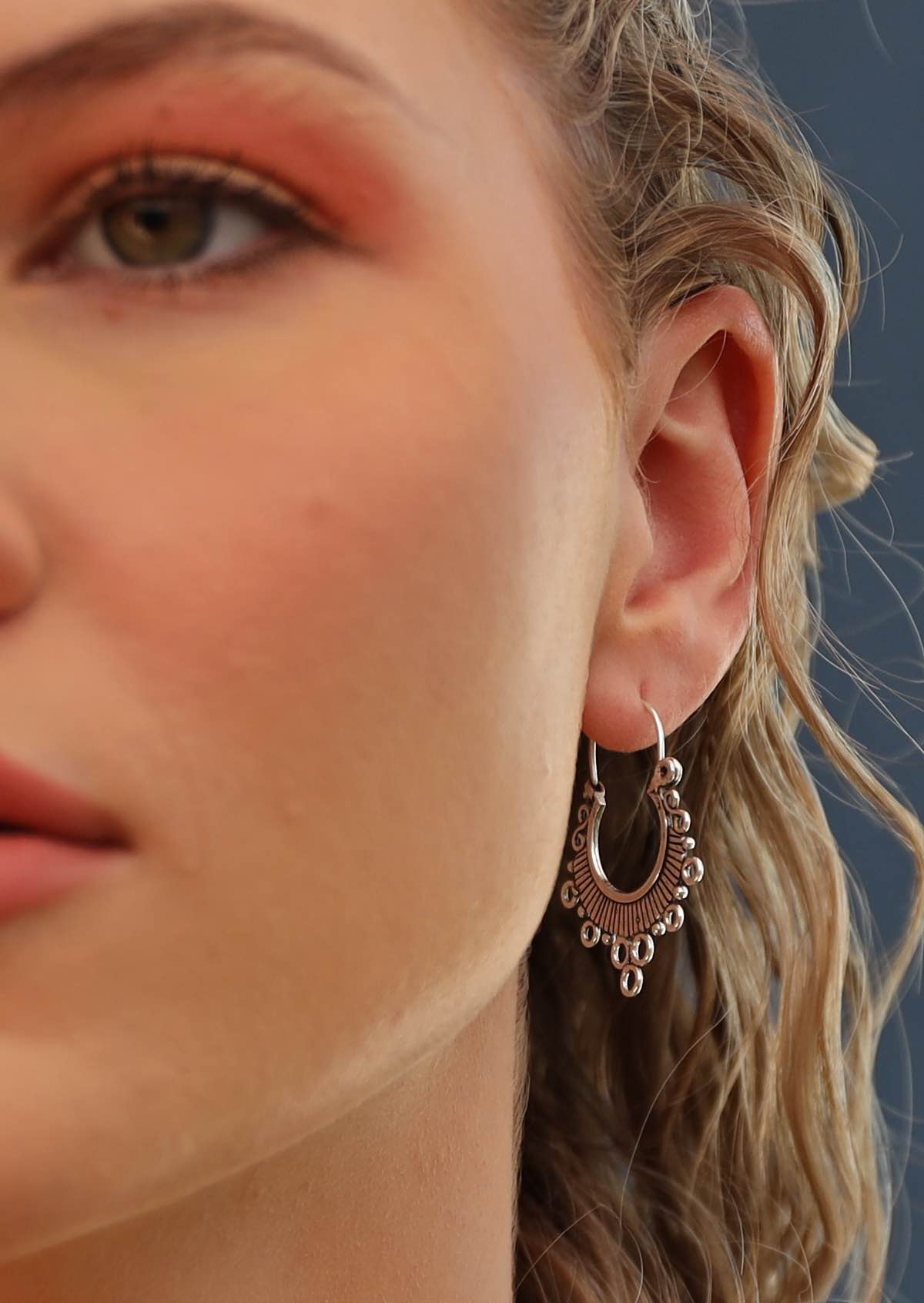 woman wearing silver hill tribe earrings 