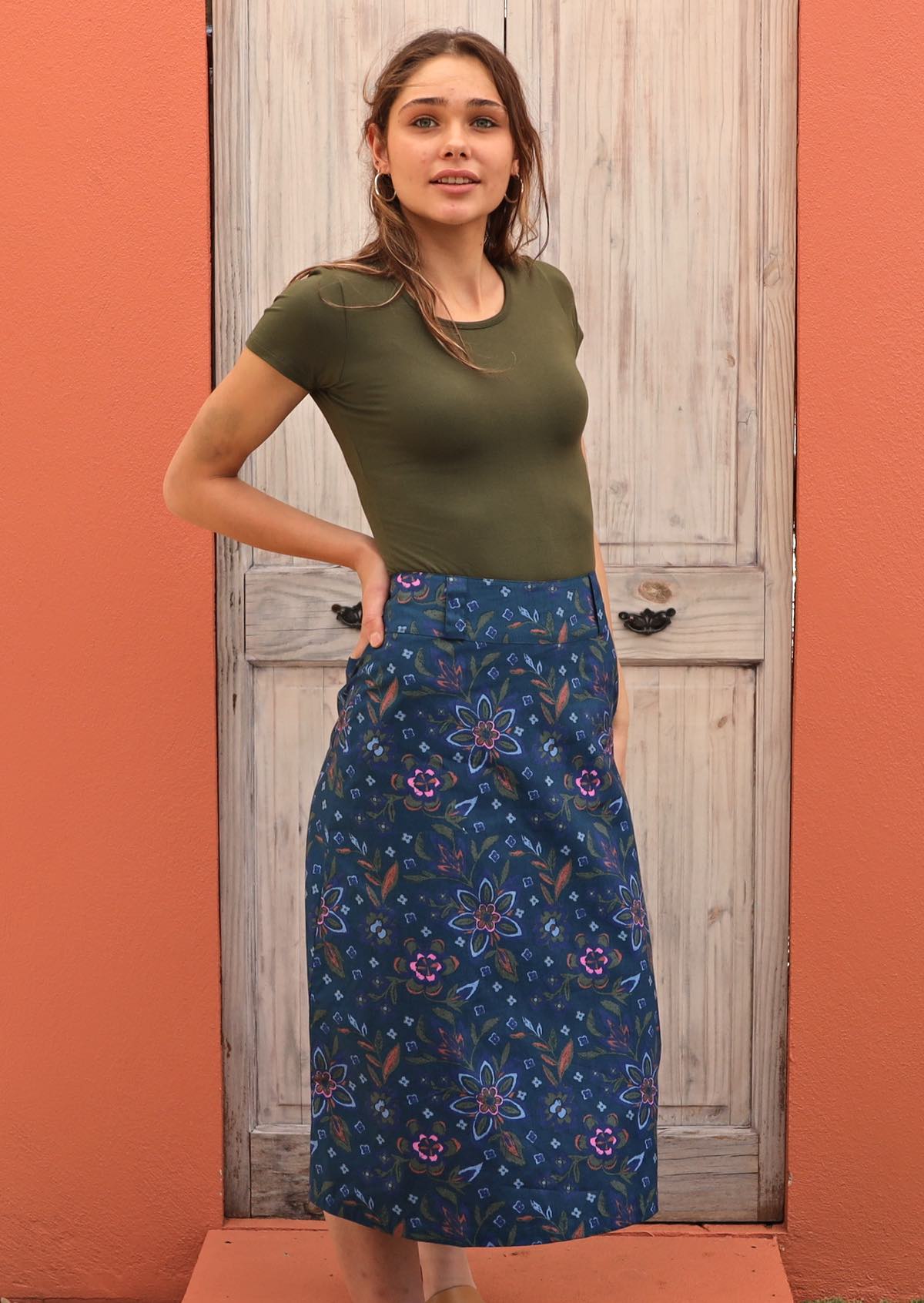 Model pairs cotton skirt with a green top to complement the orange, green and pink colour of the floral print. 