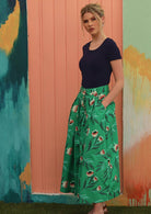 Model wears mint green cotton skirt with box pleats and pockets