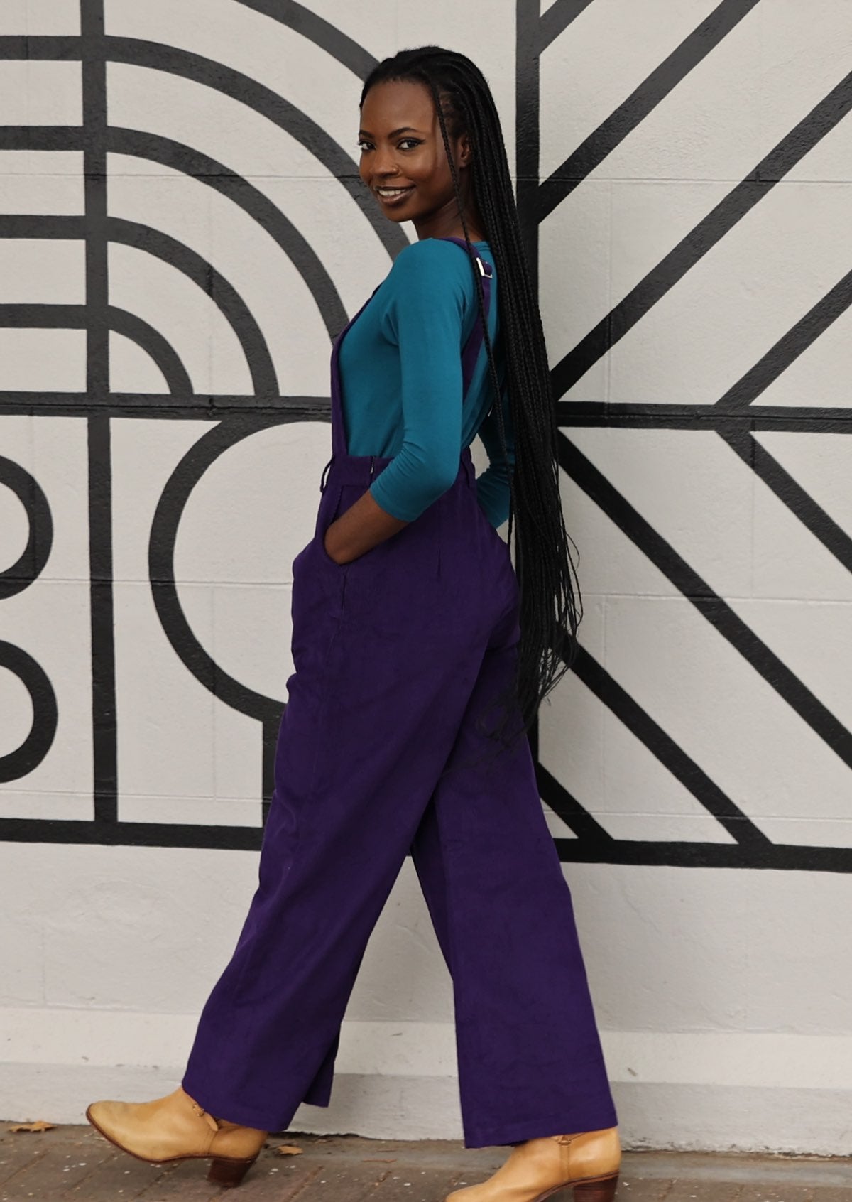 back side view of woman wearing 100% cotton purple corduroy overalls