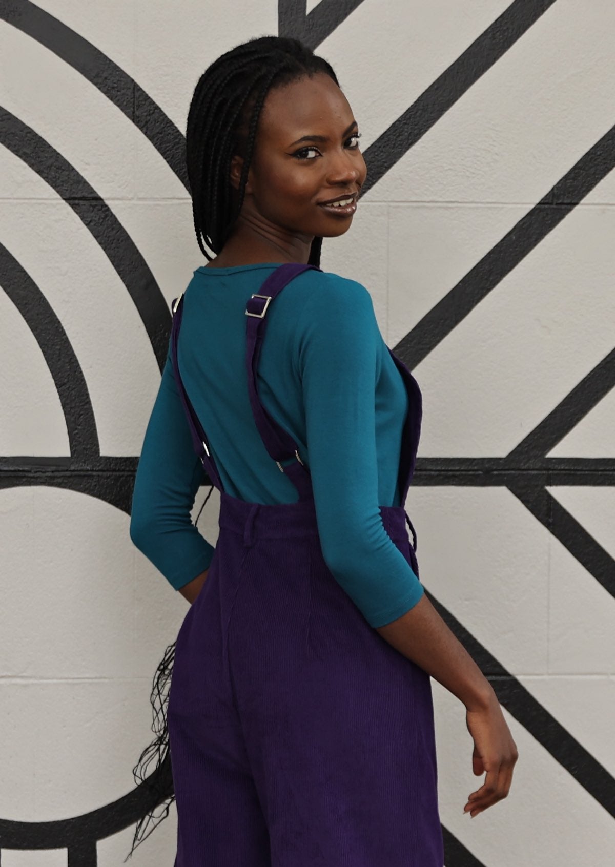 model wearing purple cotton corduroy overalls back view