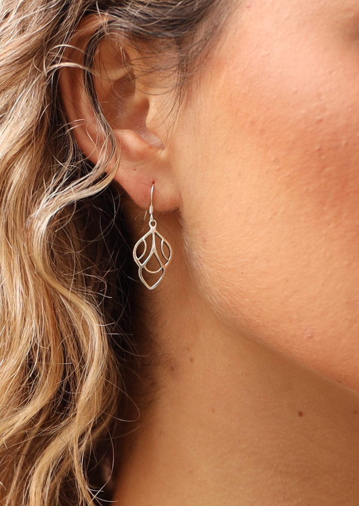 Silver art deco inspire dangly earrings on woman's ear