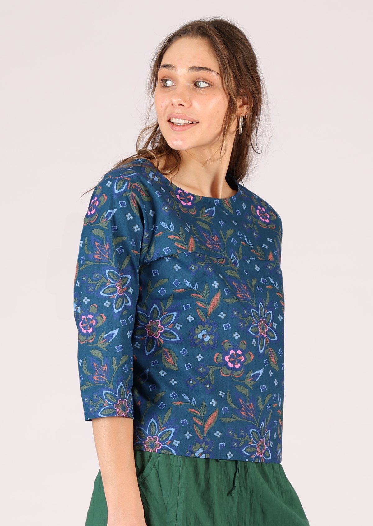 Model wears 3/4 sleeve cotton top with a floral print. 
