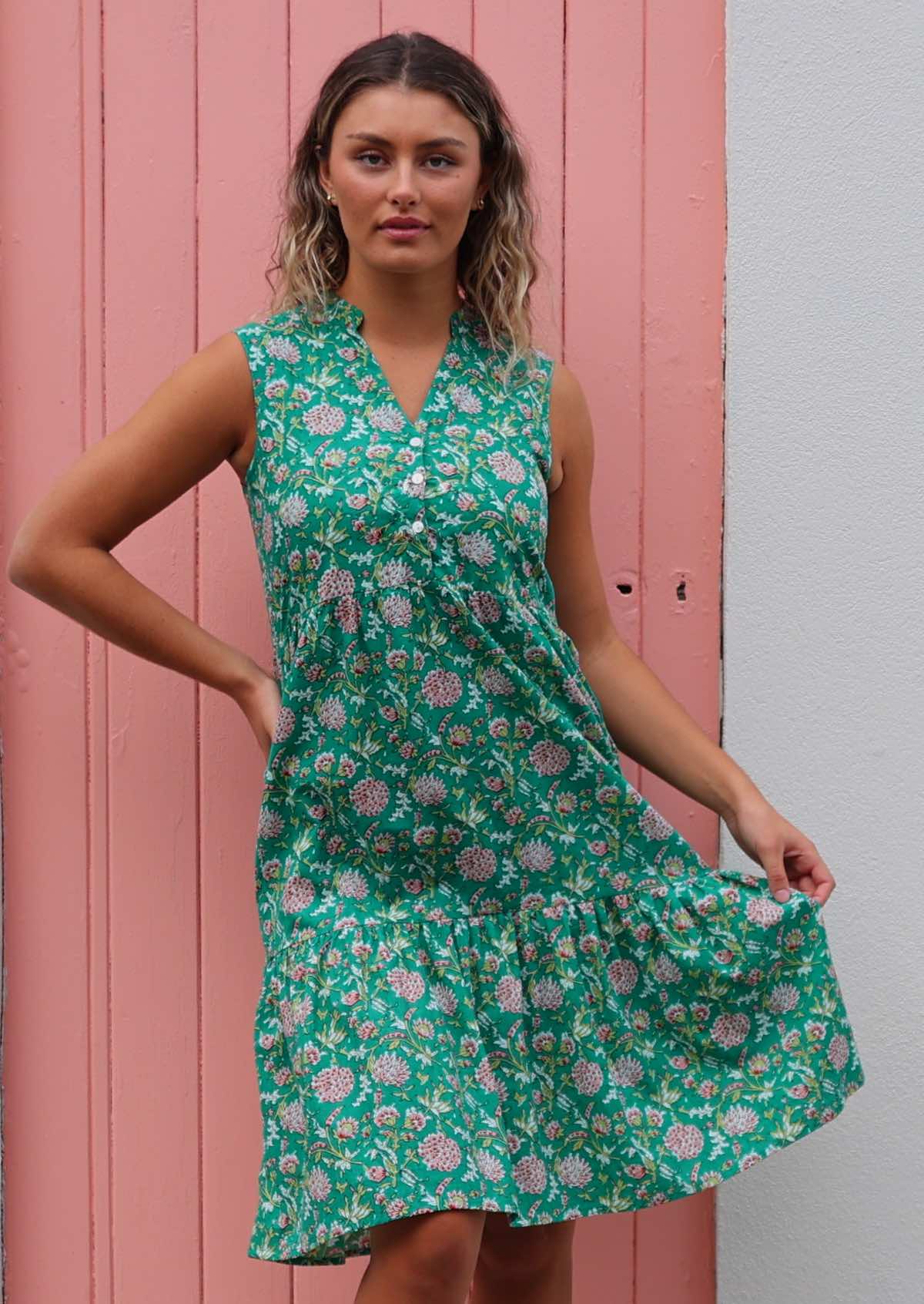 Woman poses in 100% cotton floral print sleeveless buttoned bodice dress with V-neckline and mandarin collar