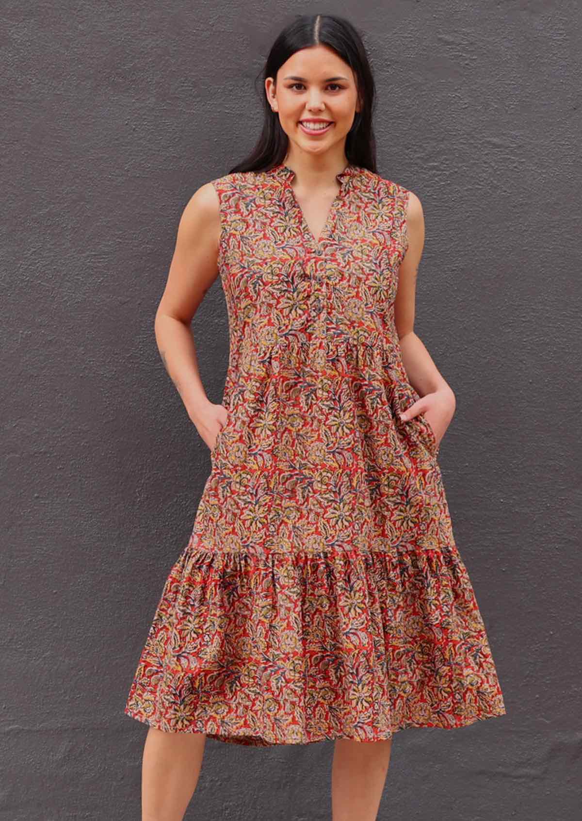 Model standing with both hands in pockets wearing Wild Spice print midi length sleeveless Indian cotton sundress