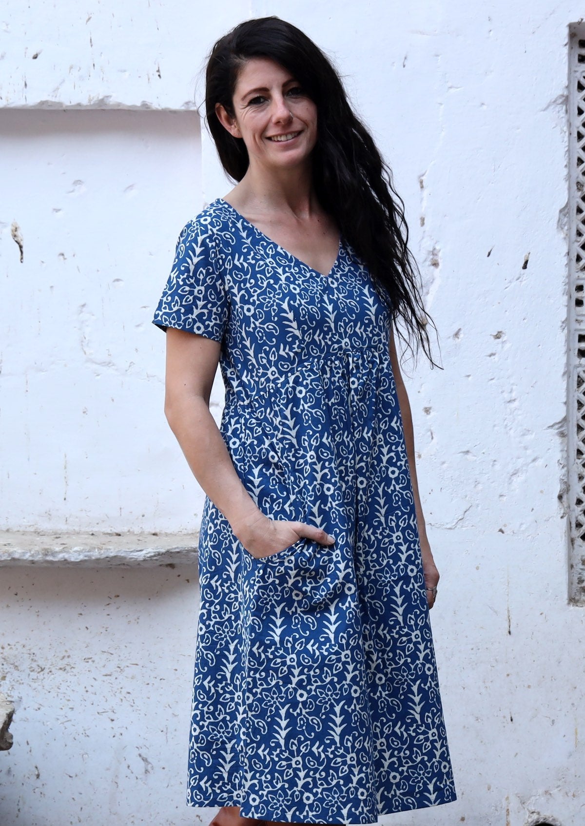 Model wears cotton relaxed fit dress with short sleeves and pockets, made in a blue based white floral Indian block print