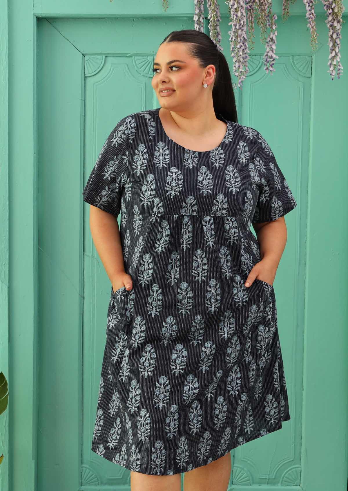 Size 18 model wearing navy blue cotton dress with Indian print and pockets