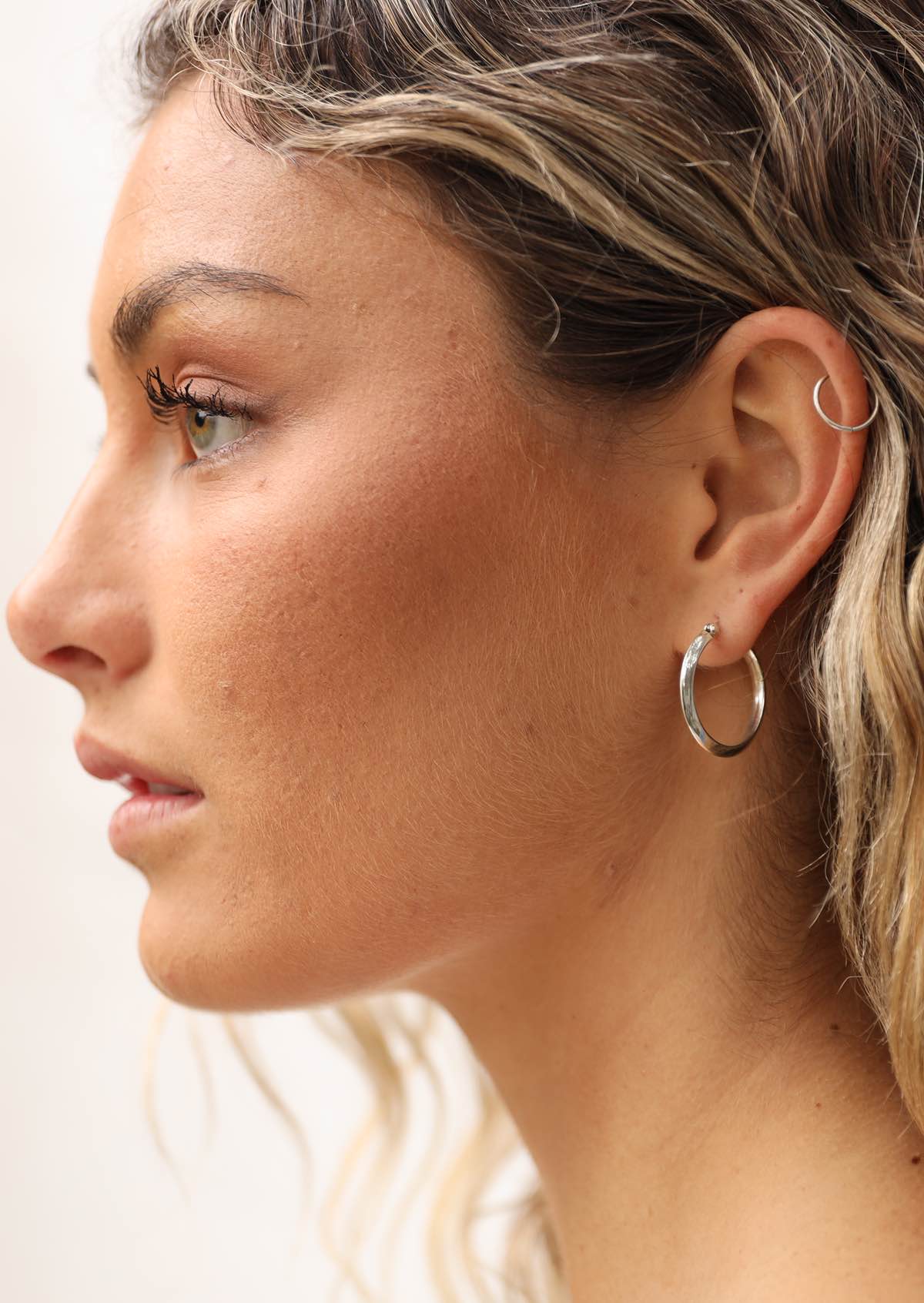 Woman with medium sizes silver hoop earring 