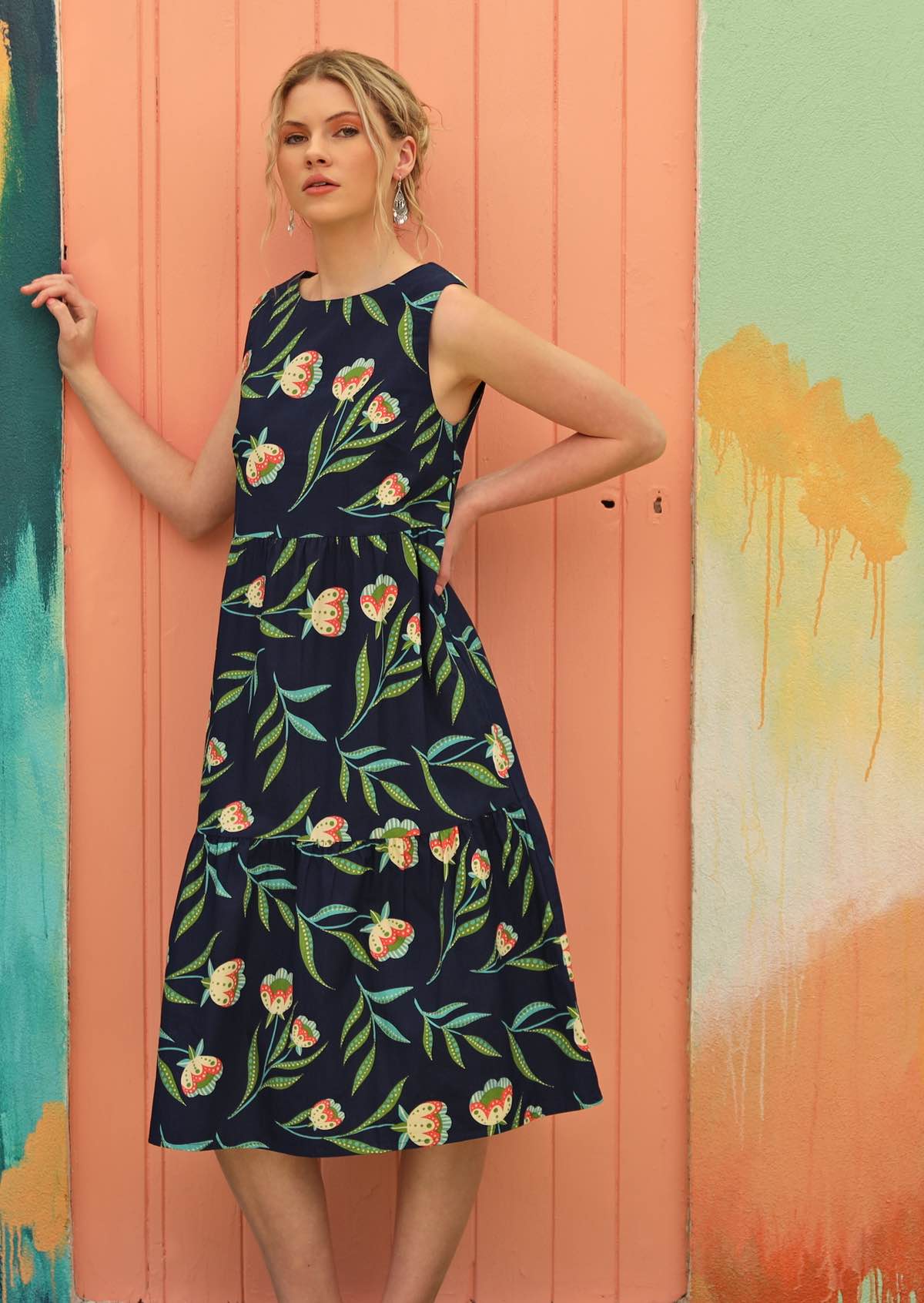 Women wears three tiered dress with floral print. 