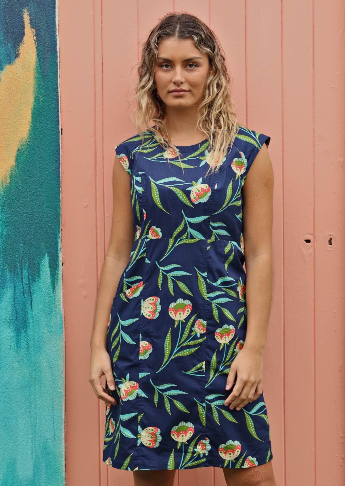 Women wears floral dress with pockets. 