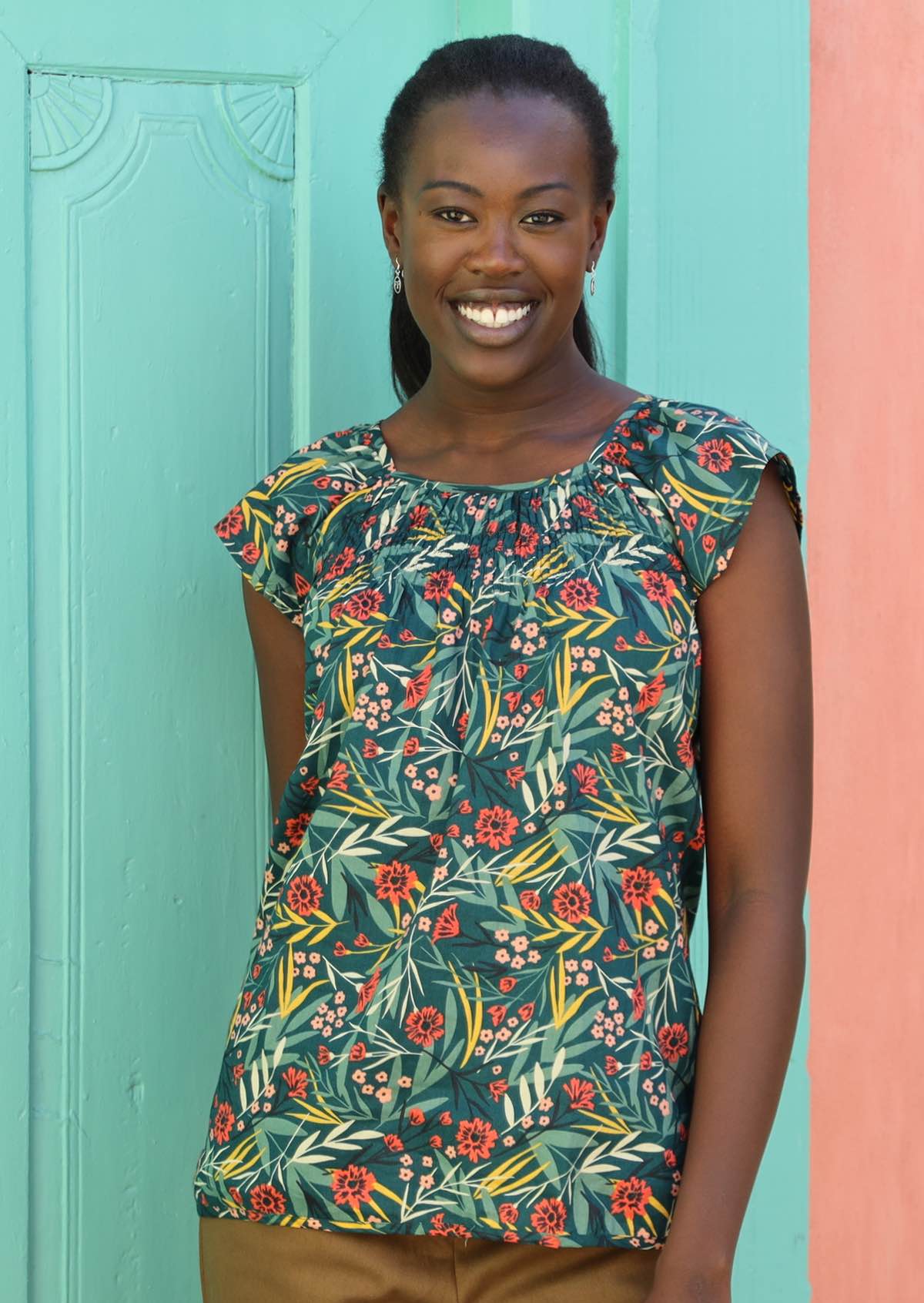 Smiling model wears 100% cotton floral top. 