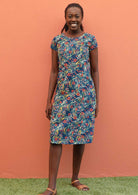 Model wears a knee length dress with a blue base. 