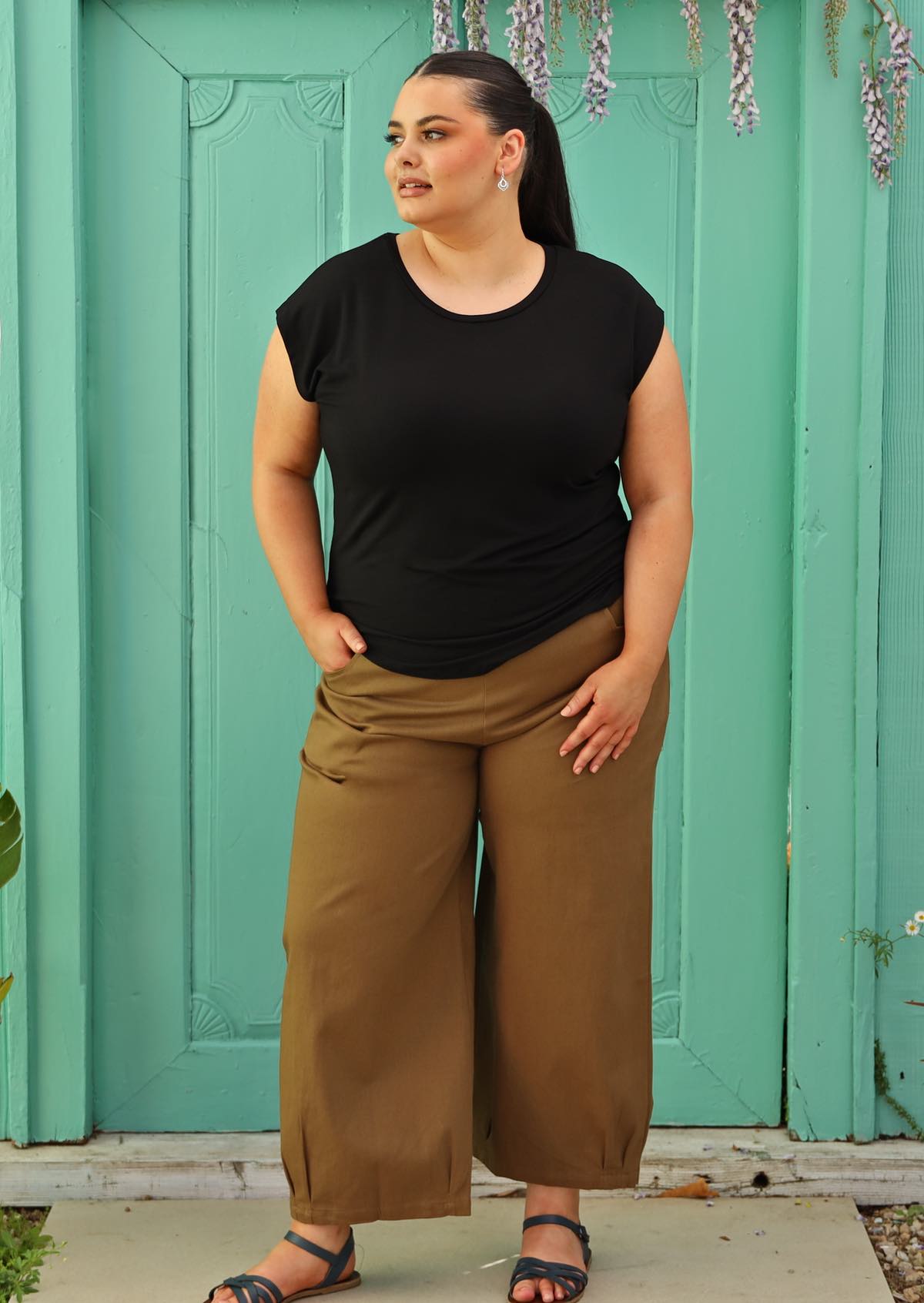 Woman wearing a soft flattering fit black rayon t-shirt and tan cotton pants.