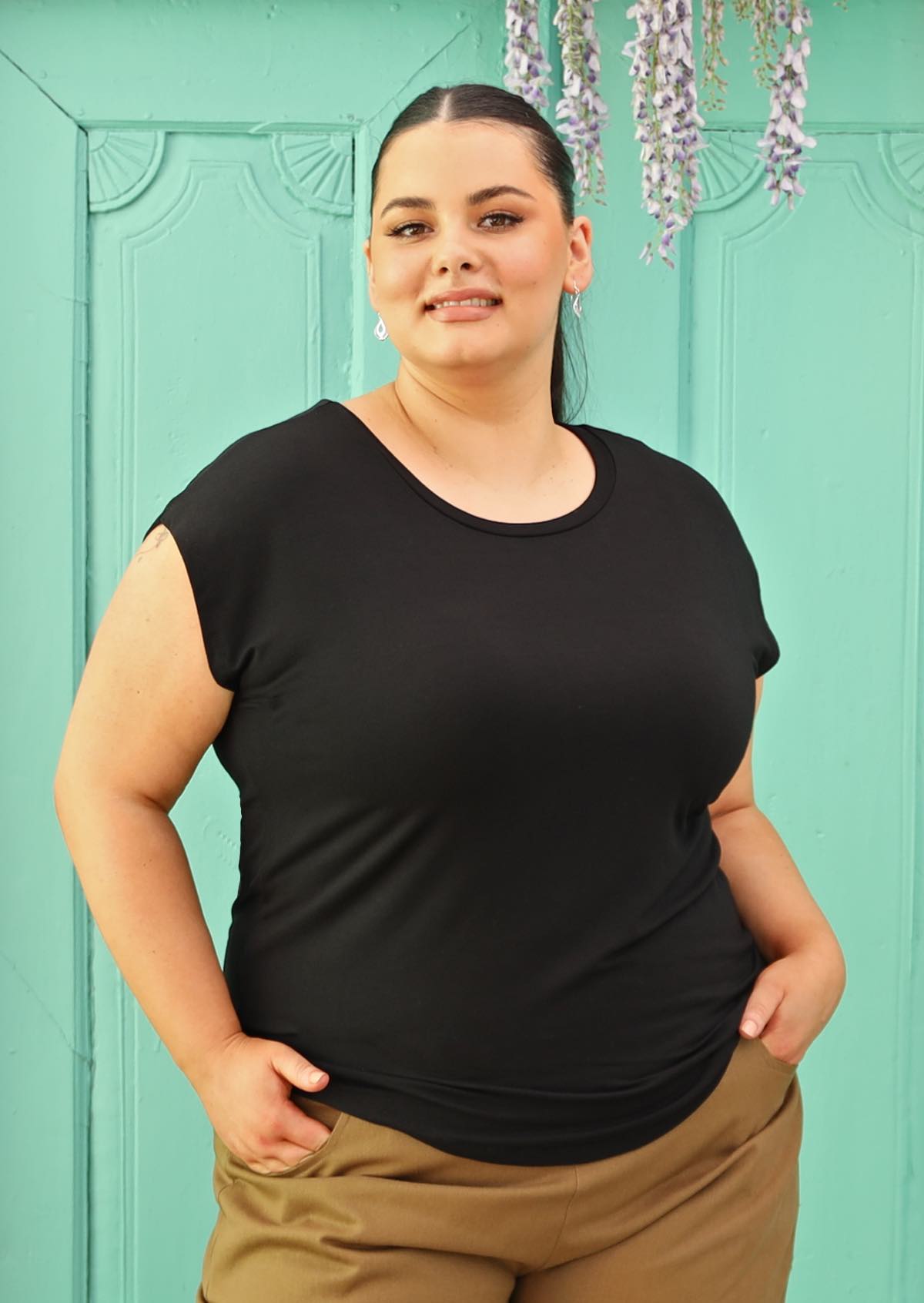 Woman with dark hair wearing a soft flattering fit black rayon jersey t-shirt.