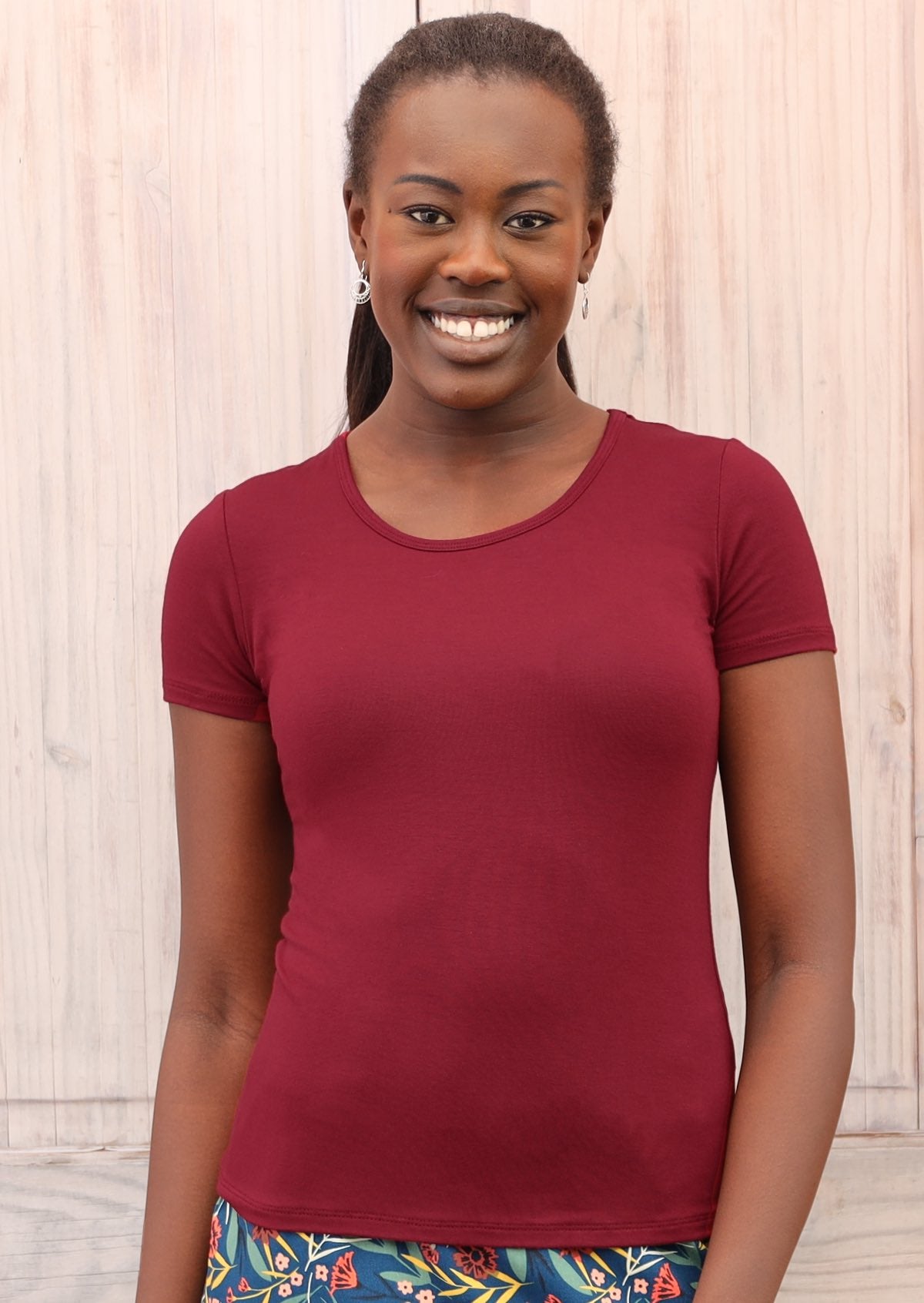 Woman wearing a scoop neck maroon rayon fitted t-shirt.