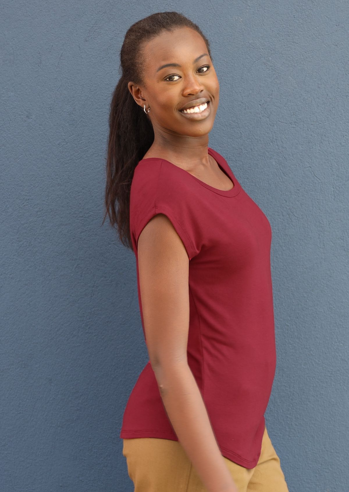 Side view of woman wearing a soft flattering fit maroon rayon jersey t-shirt.