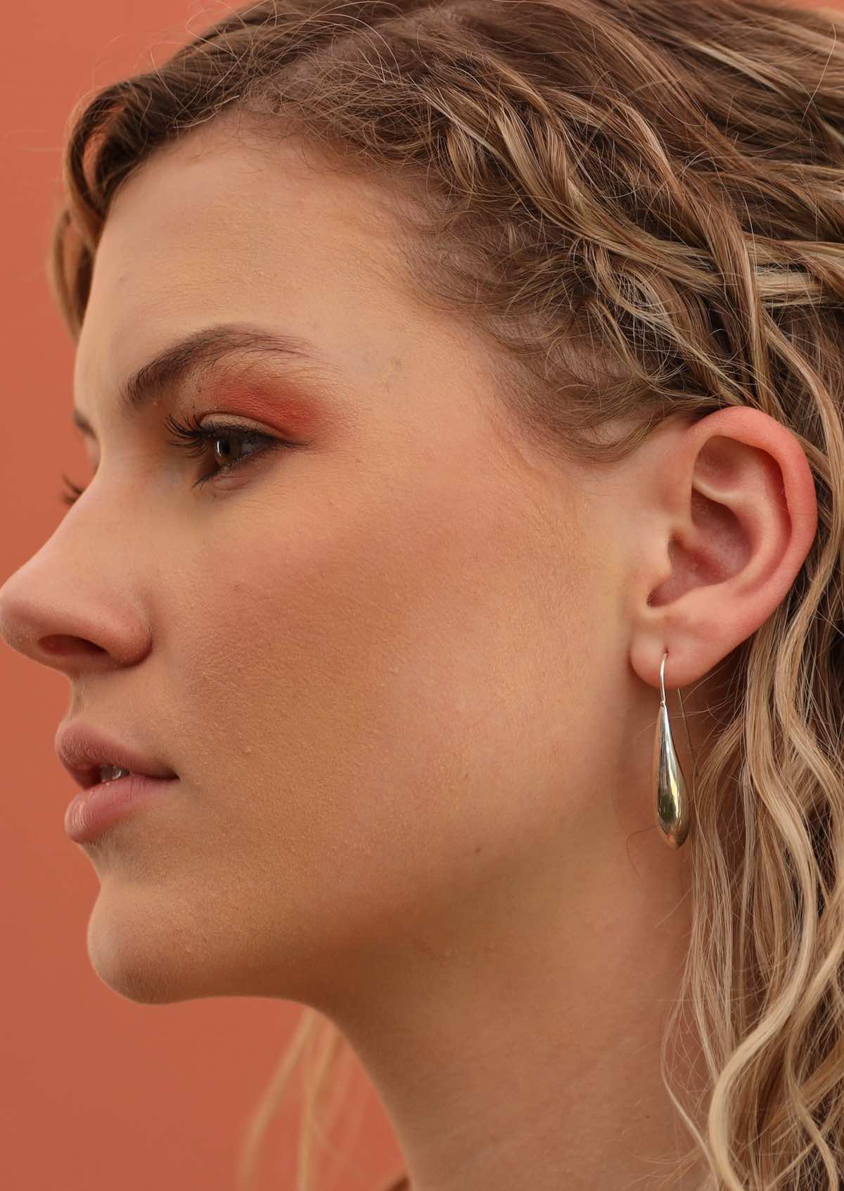 model wearing oblong silver drop earring