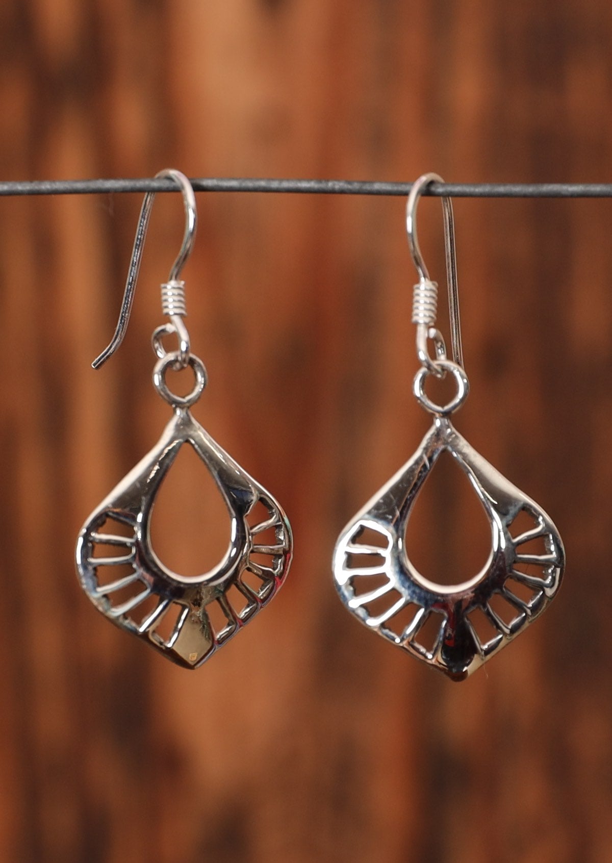 92.5% silver curved nouveau style earrings on a wire for display