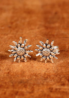 92.5% silver floral studs sit on wood for display.