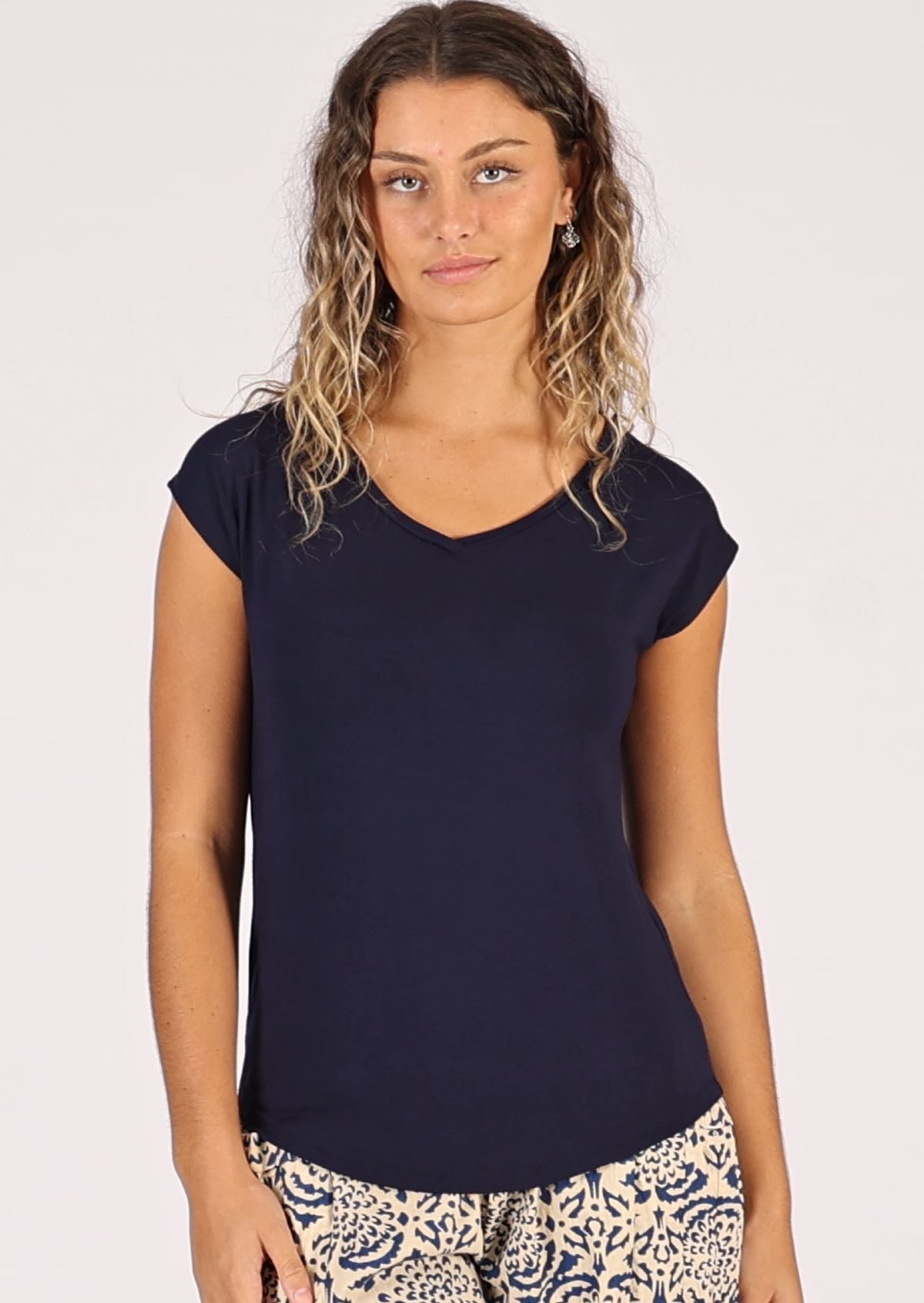Woman wearing a navy blue v-neck short cap sleeve rayon top