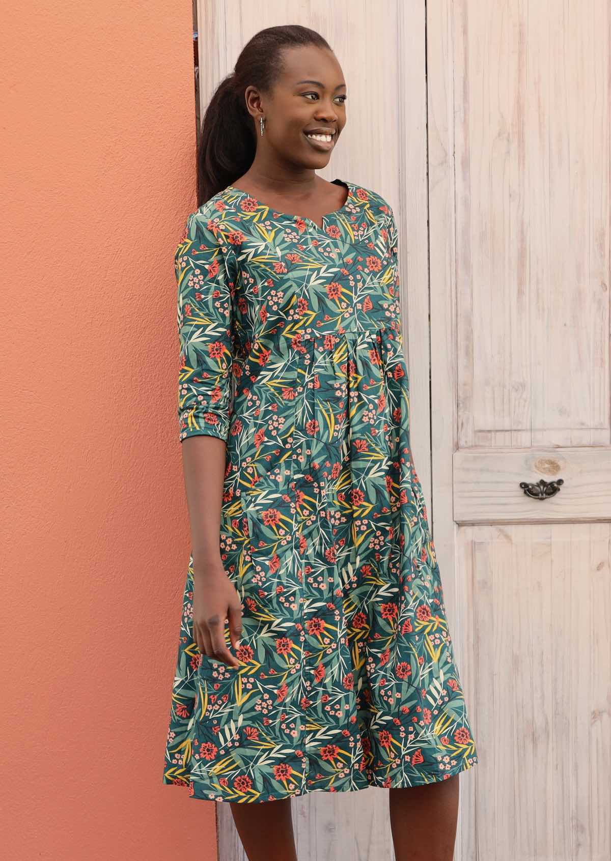 Model wears 100% cotton dress with a floral pattern and 3/4 length sleeves. 