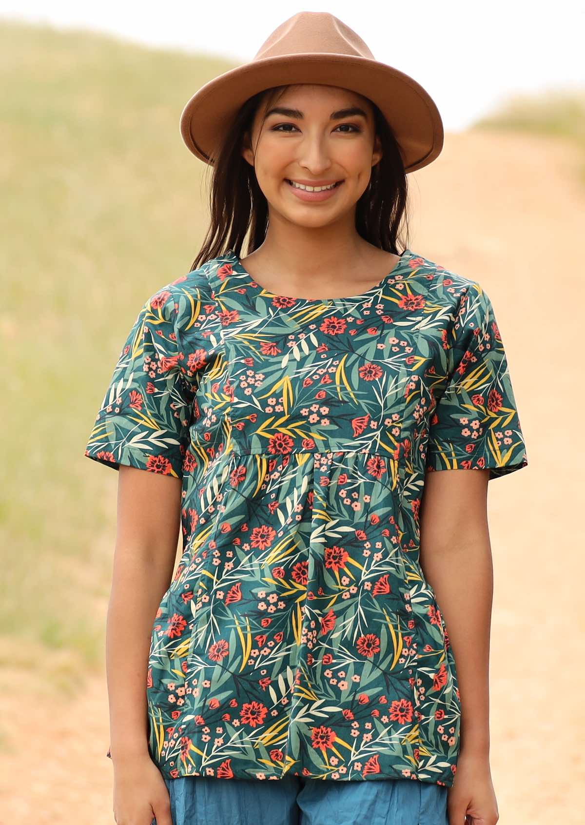 Model wears a cotton top with a round neckline and pockets. 