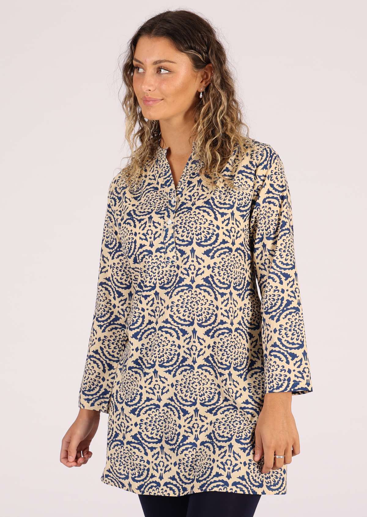 Model wears a tunic with small gatherings in the shoulders. 