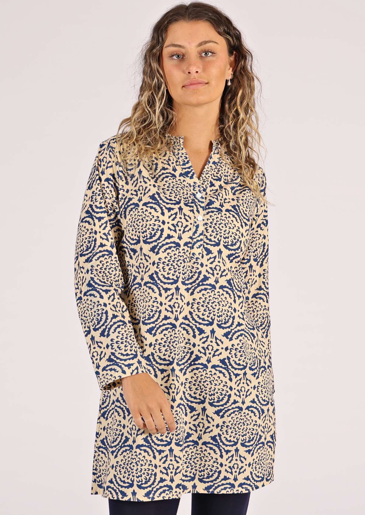 Model wears a-line shirt dress with a floral pattern. 