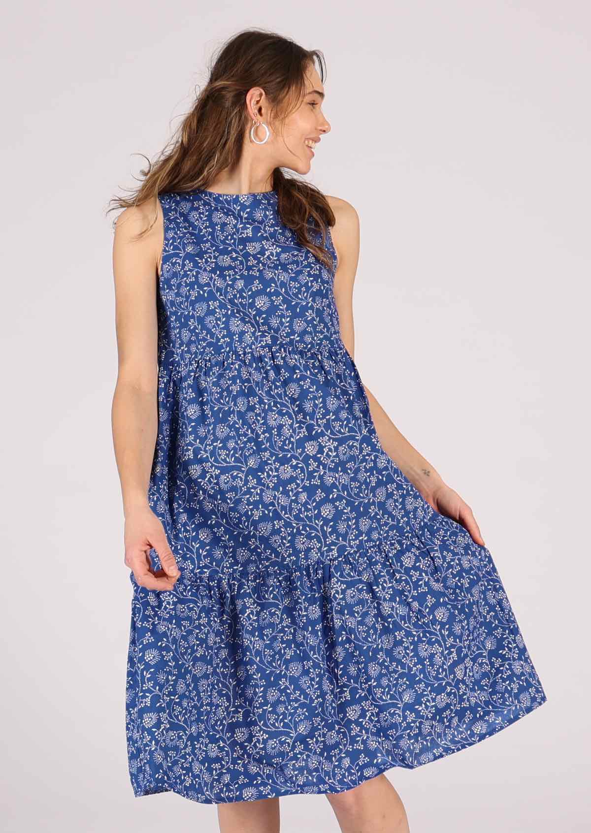 Model showcases blue and white floral dress with a keyhole button back closure. 
