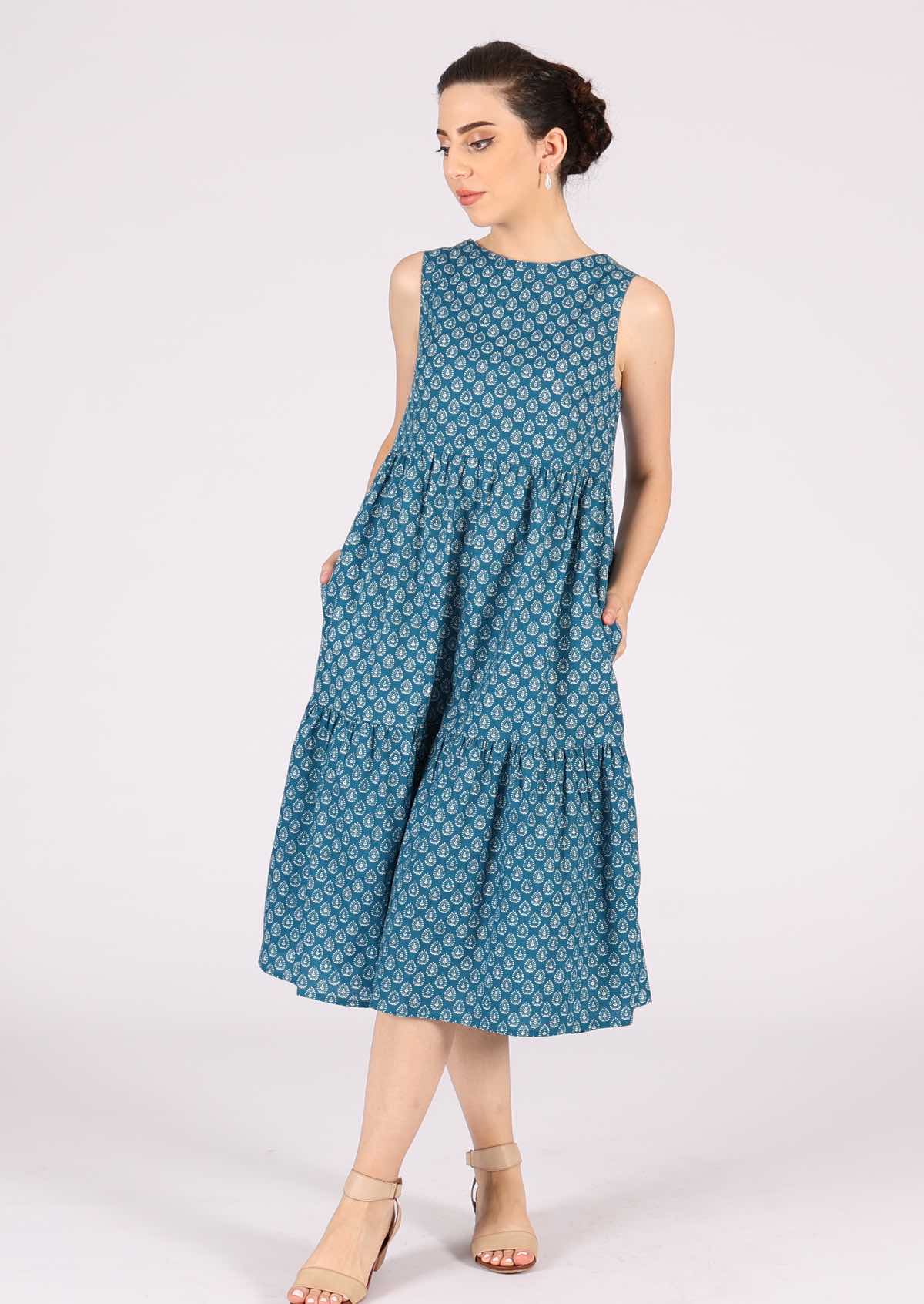 Model wears 100% cotton dress with a white ornamental pattern on a blue base. 