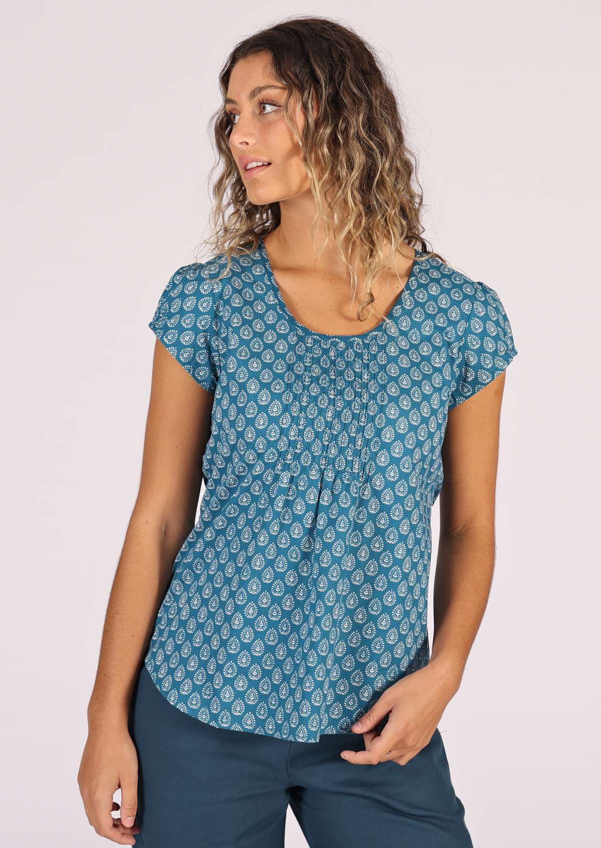 Model wears white on blue printed cotton top with cap sleeves and a low round neckline