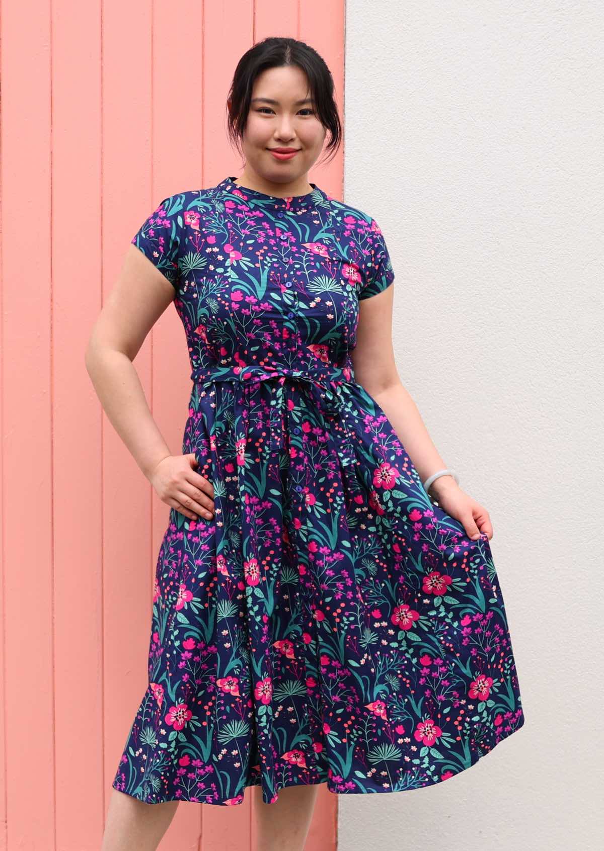 Woman standing in Navy cotton floral maxi dress with v-neck and pockets