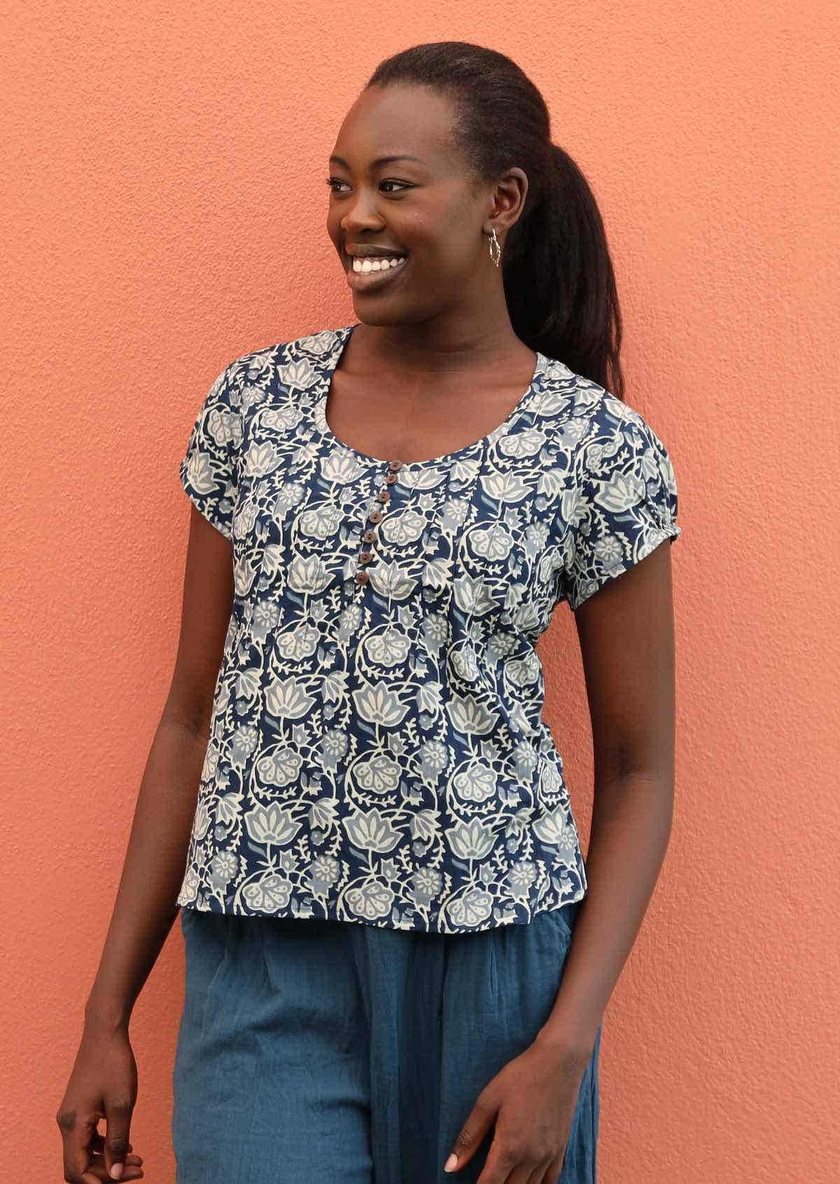 Smiling model wears 100% cotton top with a scooped neckline. 