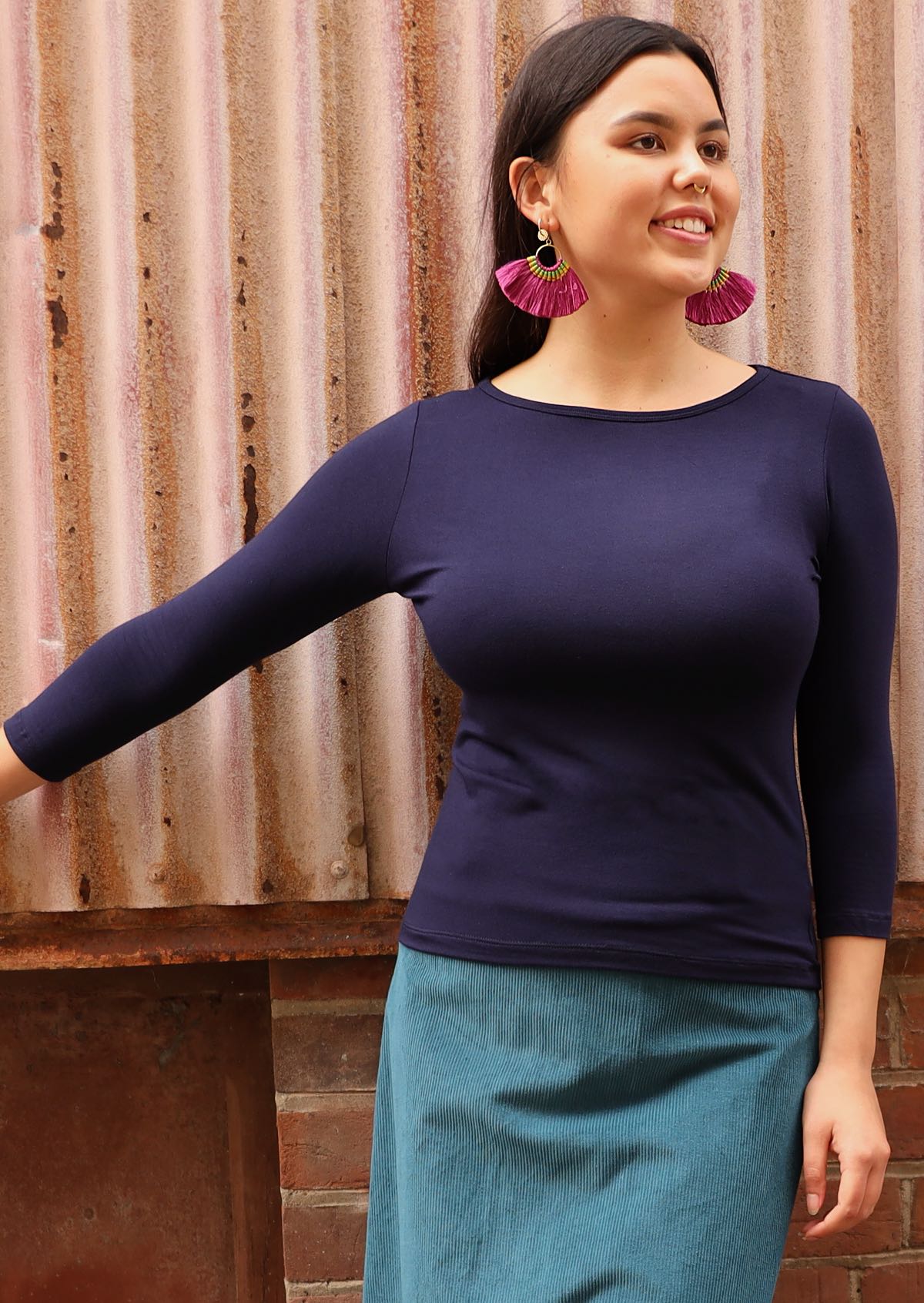Woman wearing a rayon boat neck navy blue 3/4 sleeve top.