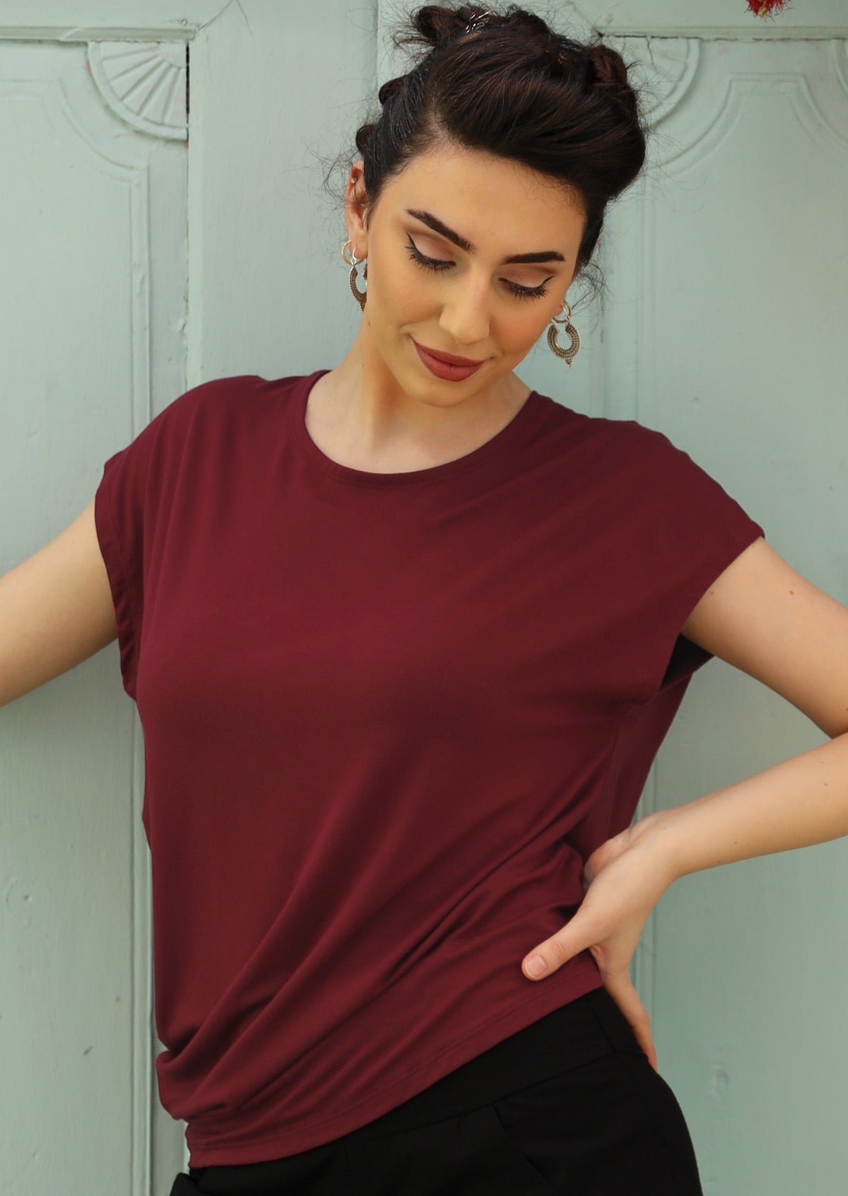 Woman wearing maroon soft stretch rayon women's top with black pants