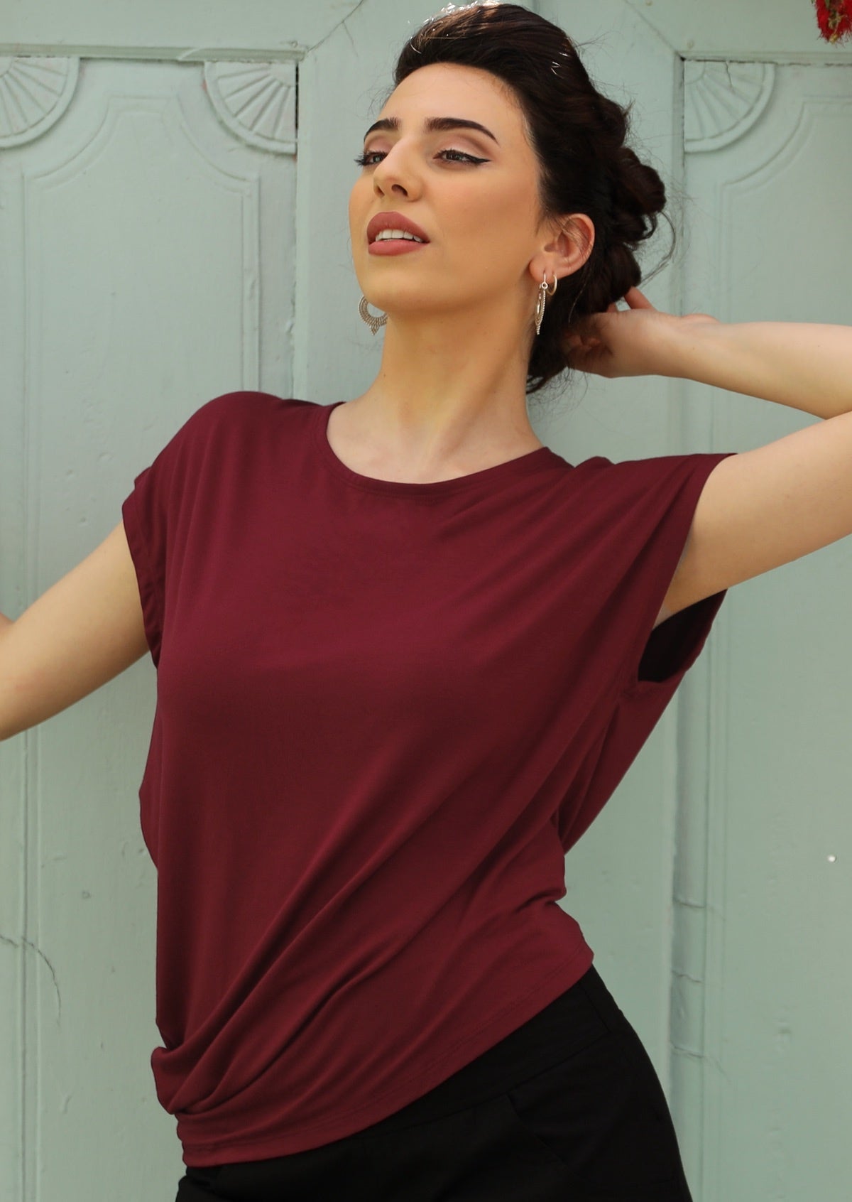 Woman wearing a maroon relaxed fit asymmetrical detail