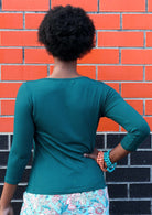 Woman with black short hair wearing a rayon boat neck teal 3/4 sleeve top.