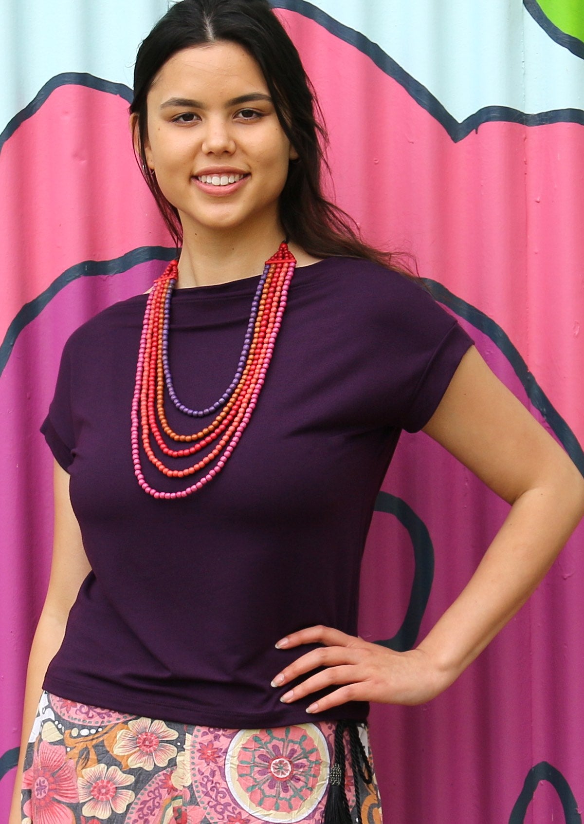 Woman wearing a wide neck mod purple stretch rayon boat neck top