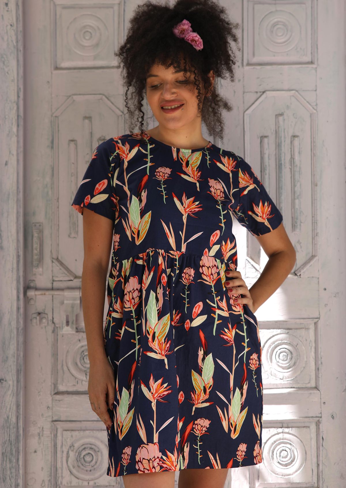 Woman wearing dress with navy background pink and green toned flowers100% Cotton Designed in Australia