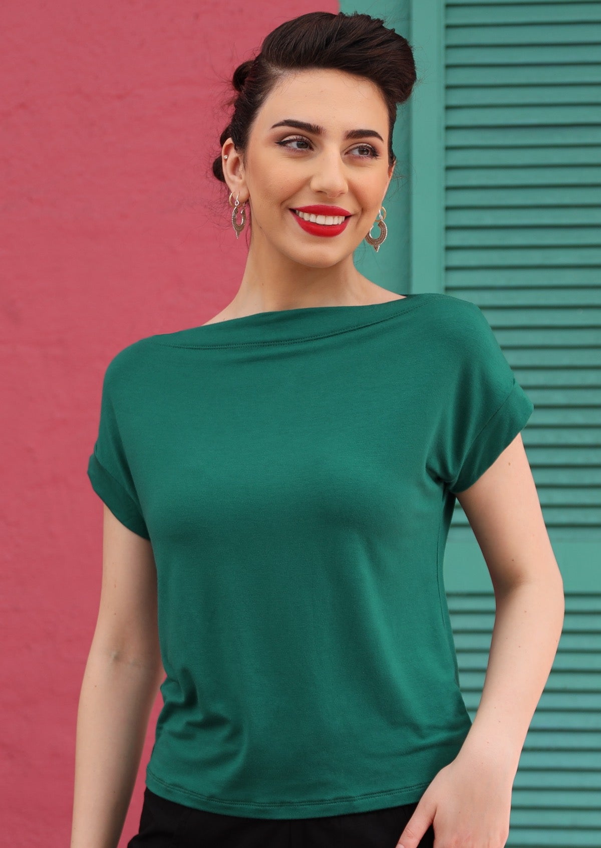 Woman wearing a wide neck mod green stretch rayon boat neck top