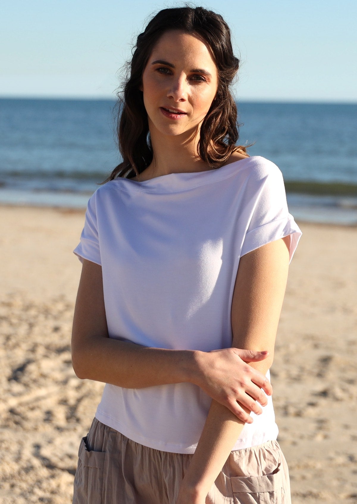 Woman wearing a wide neck mod white stretch rayon boat neck top