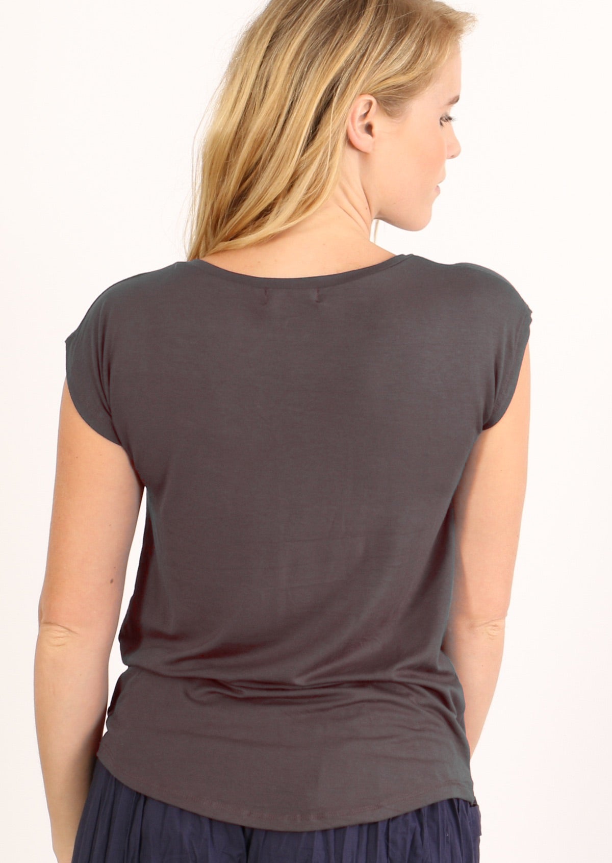 Back view of woman with blonde hair wearing a dark grey v-neck short cap sleeve rayon top