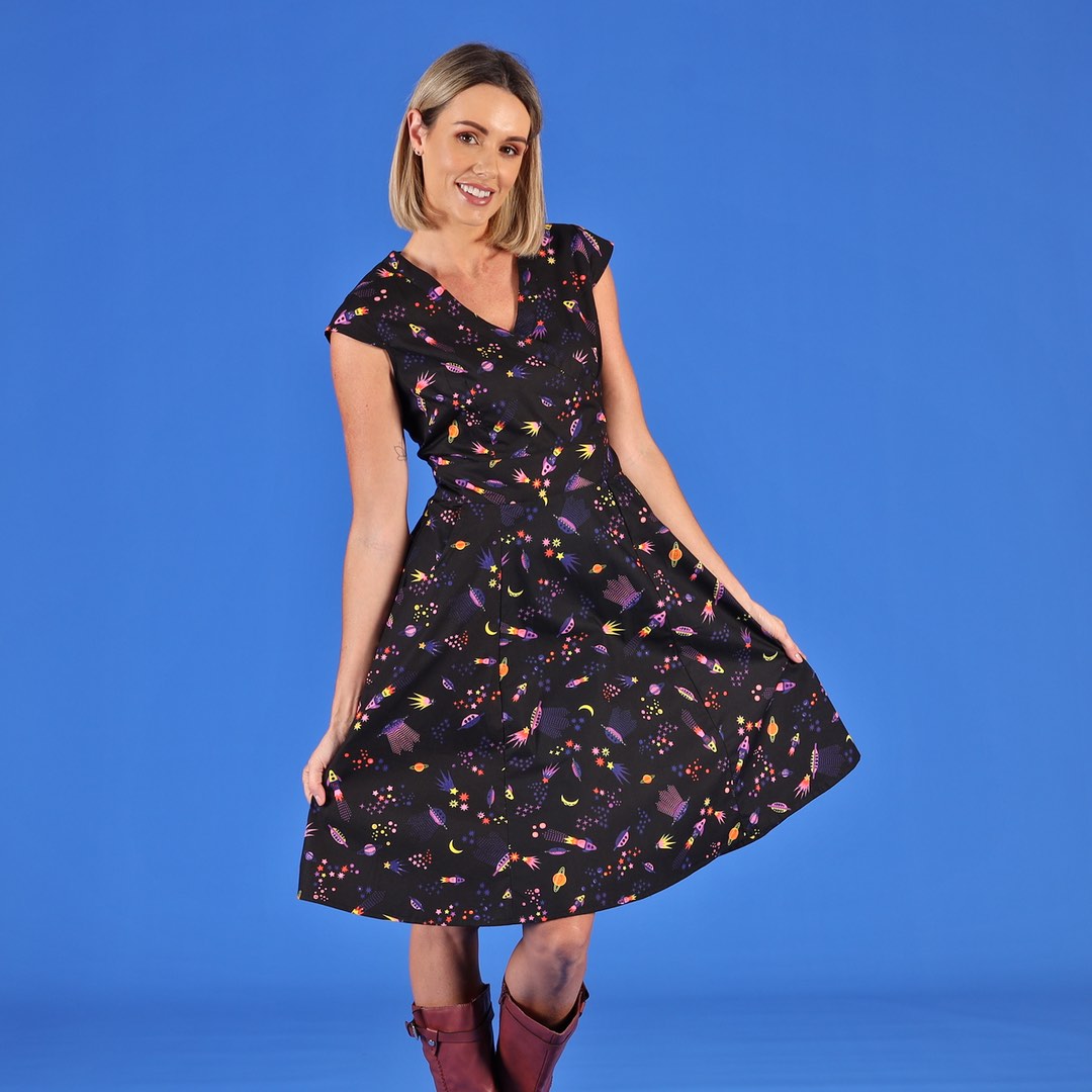 woman wearing black cotton dress with fun space themed print 
