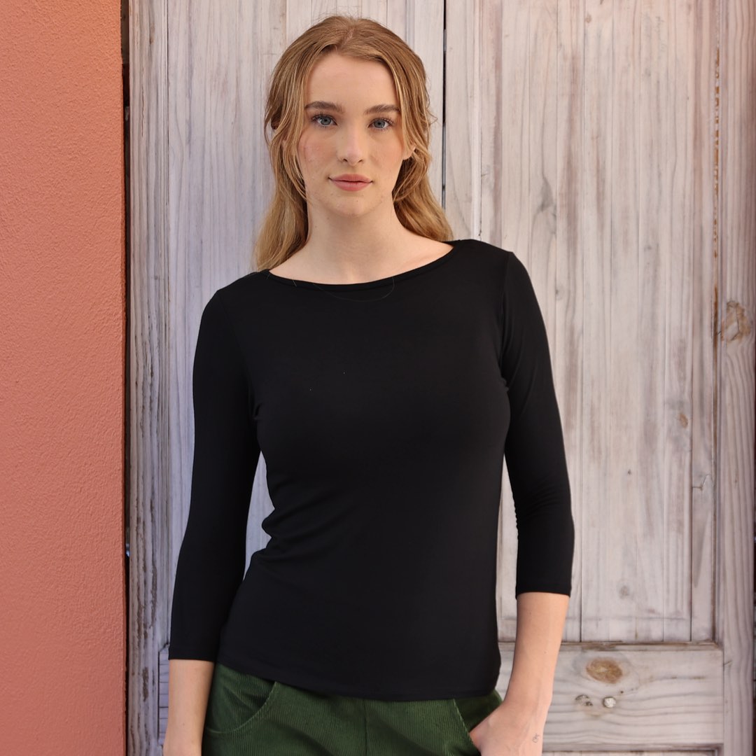 Woman wearing black boat neck top 
