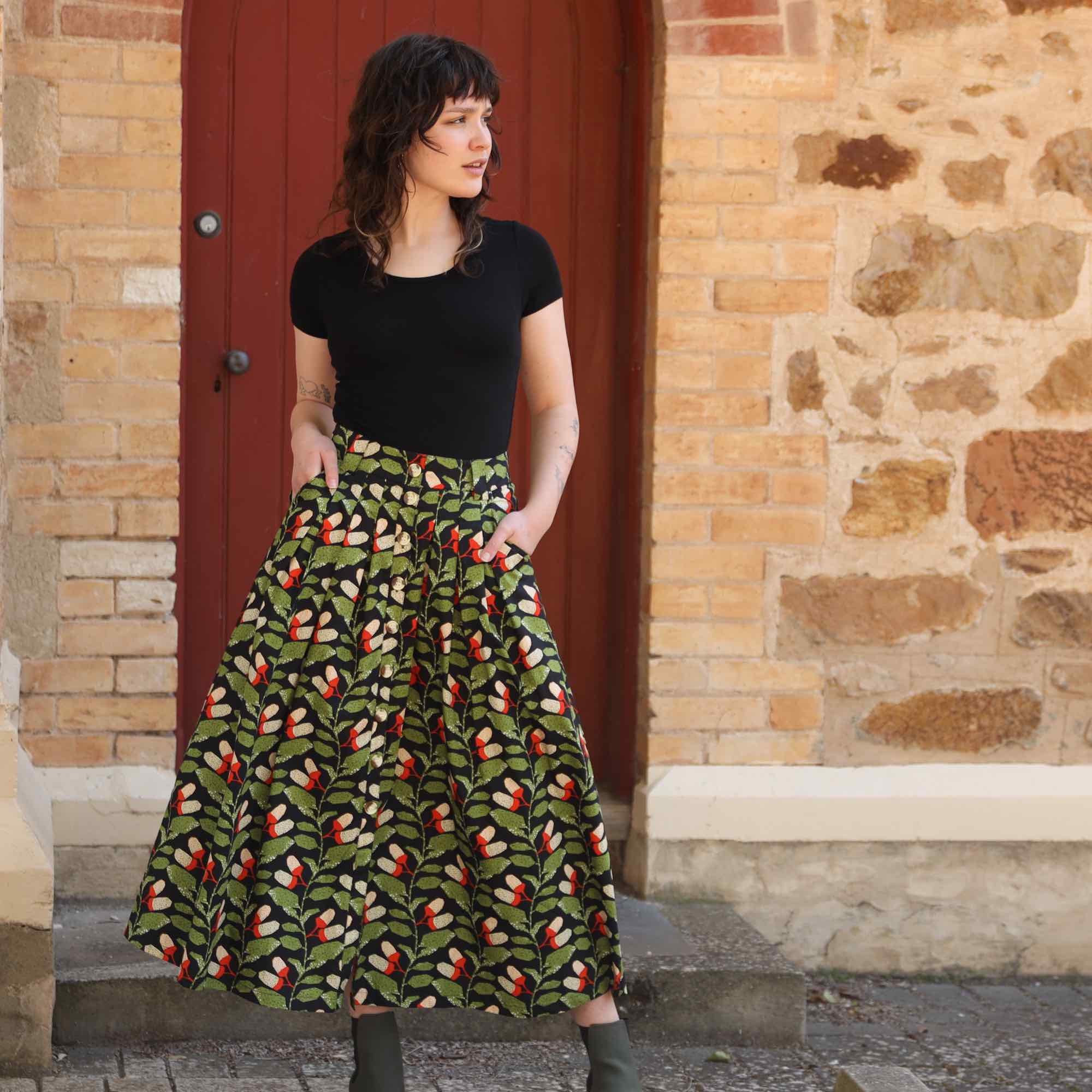 Woman wearing black cotton maxi skirt with pockets and buttons down the front