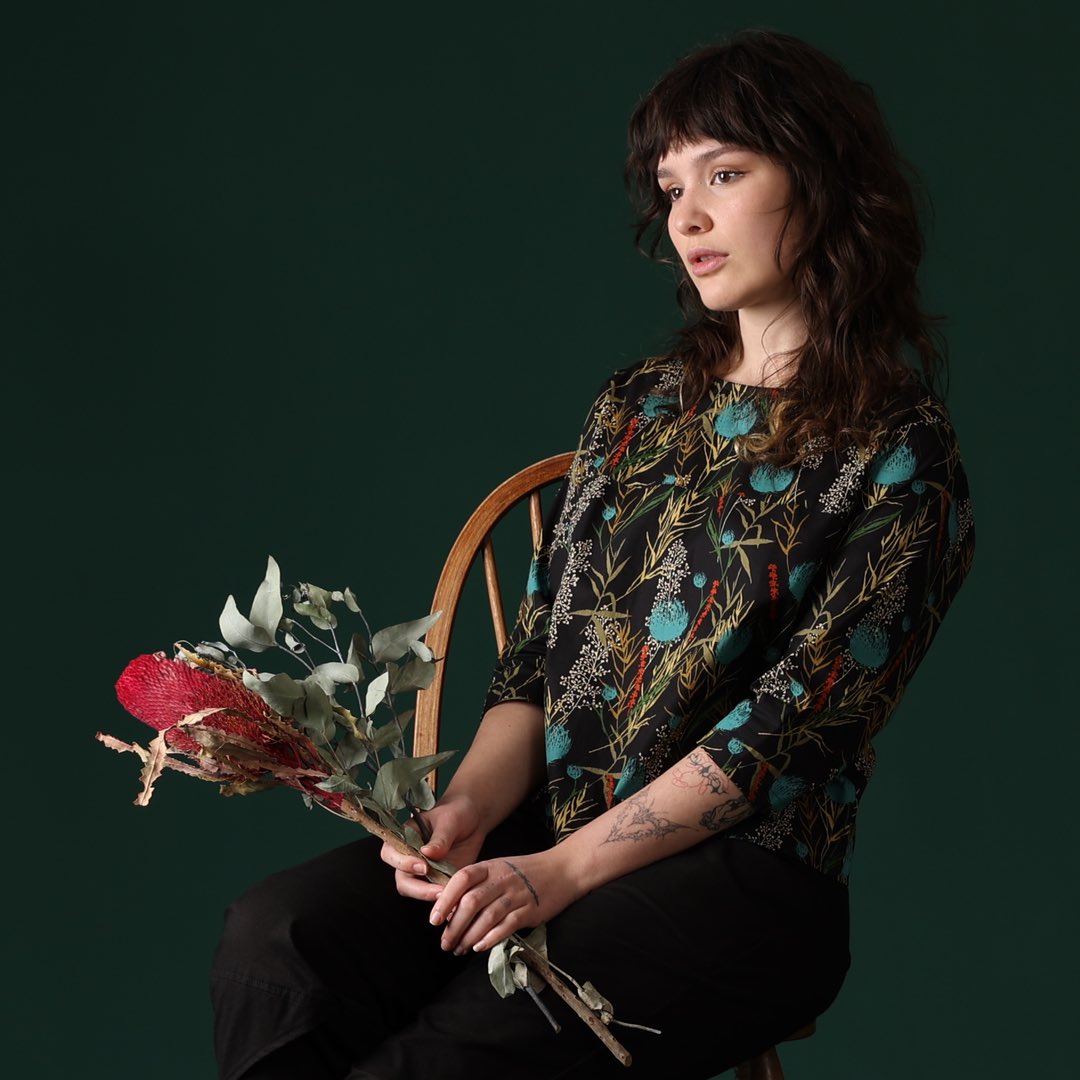 woman holding flowers wearing long sleeve black cotton blouse