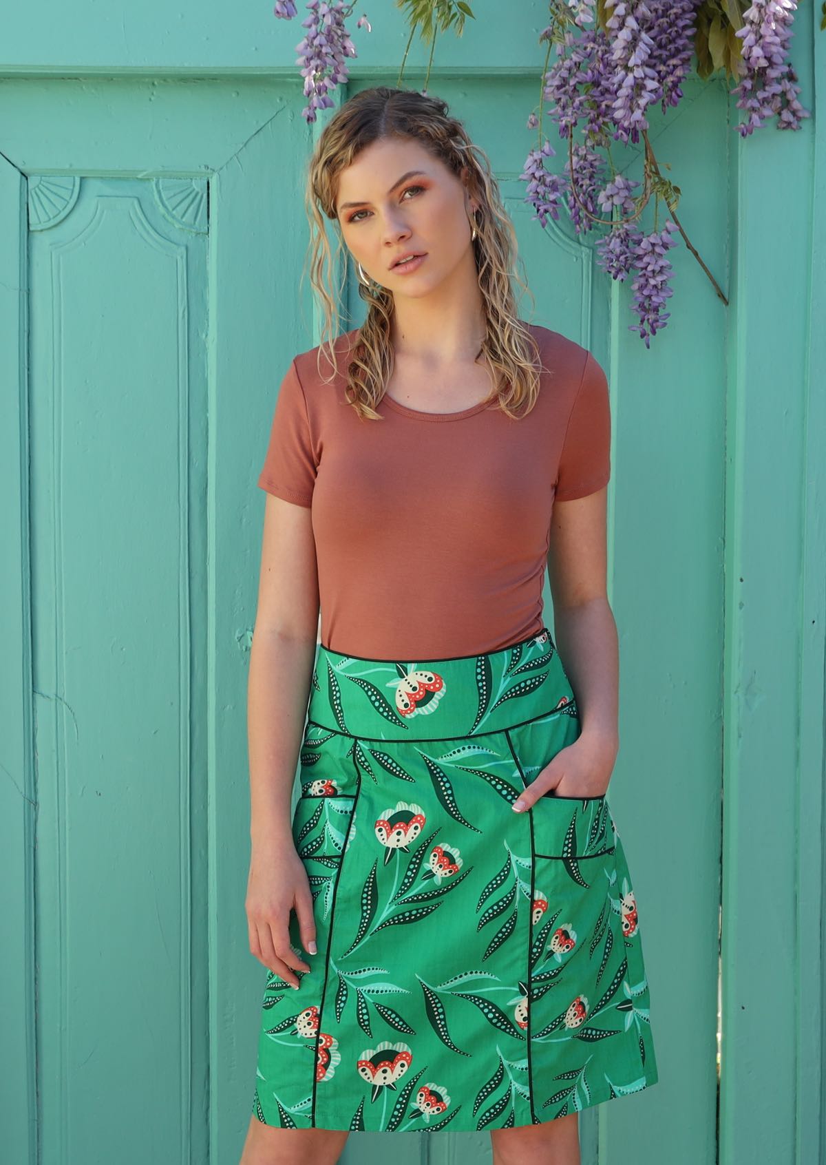 Model wears mint green cotton skirt with floral print