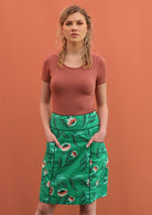 Model wears green floral cotton skirt with accent piping 