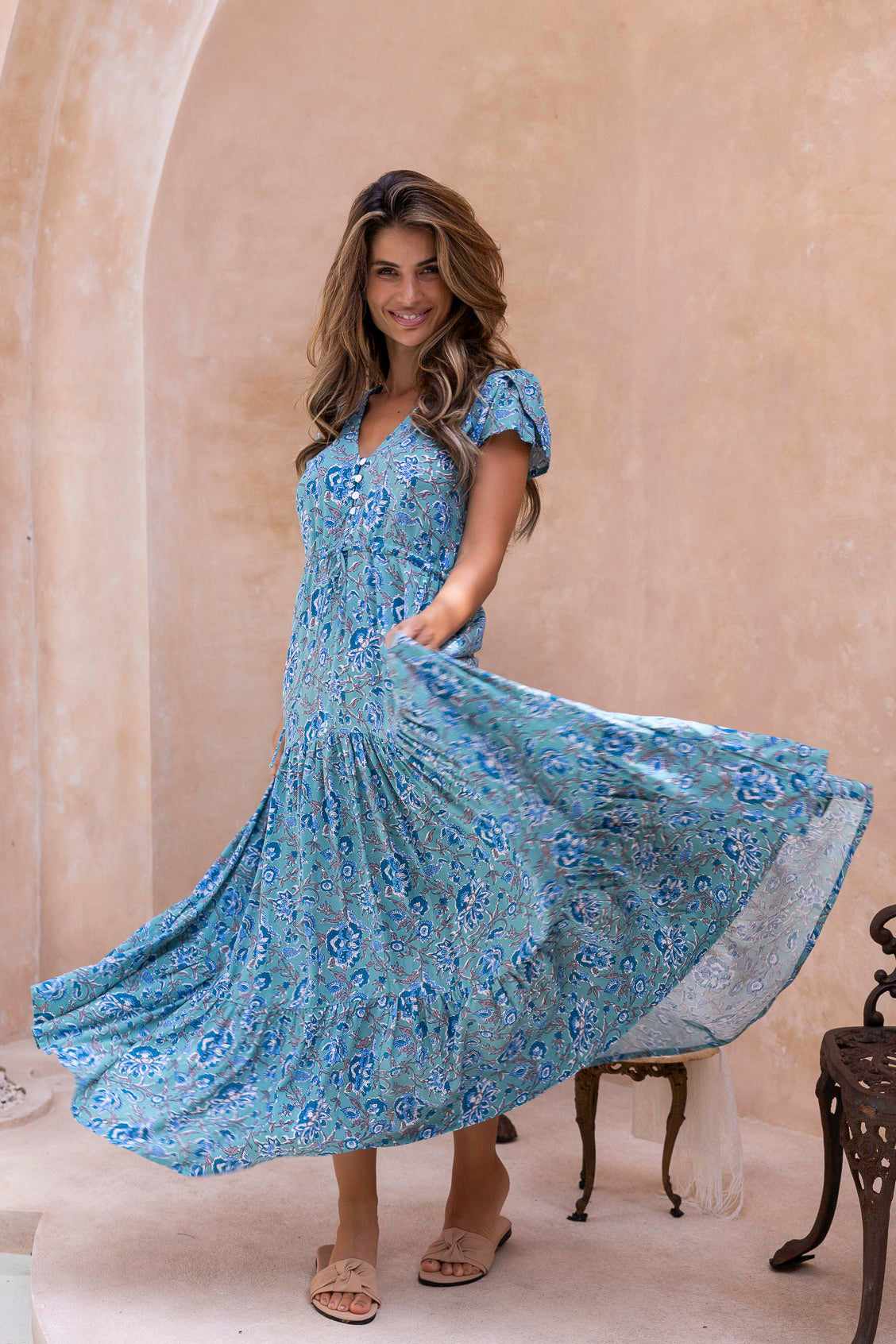 Woman in a floral maxi dress with full skirt twirling 